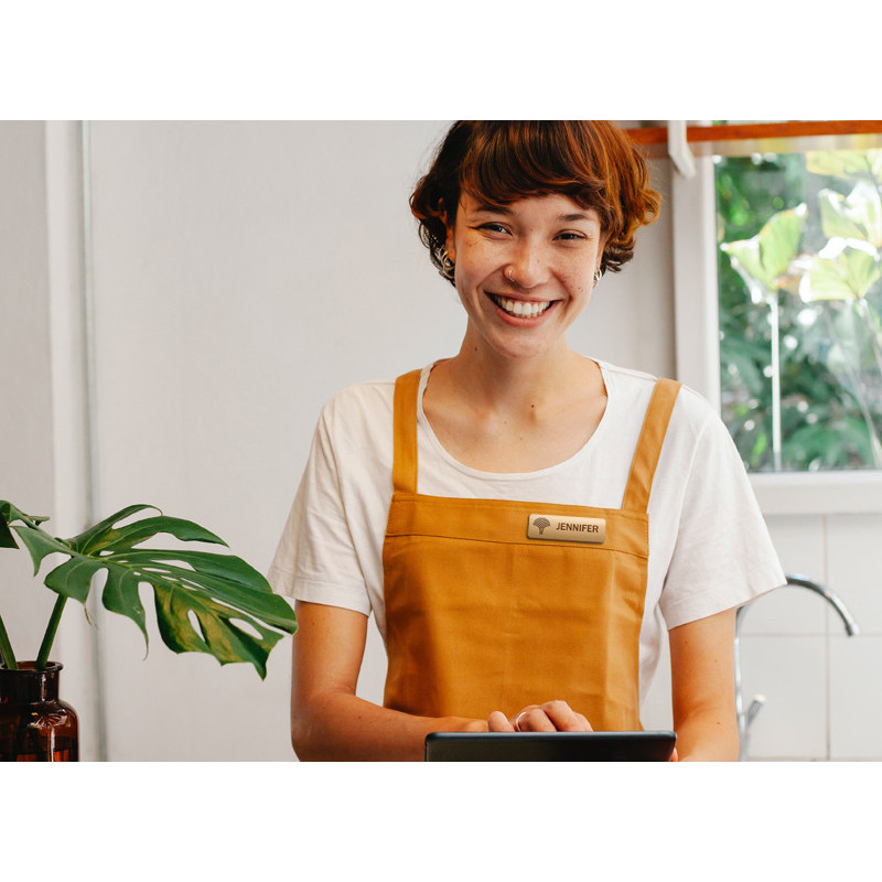 Woman wearing bamboo name badge with natural dye filled engraving